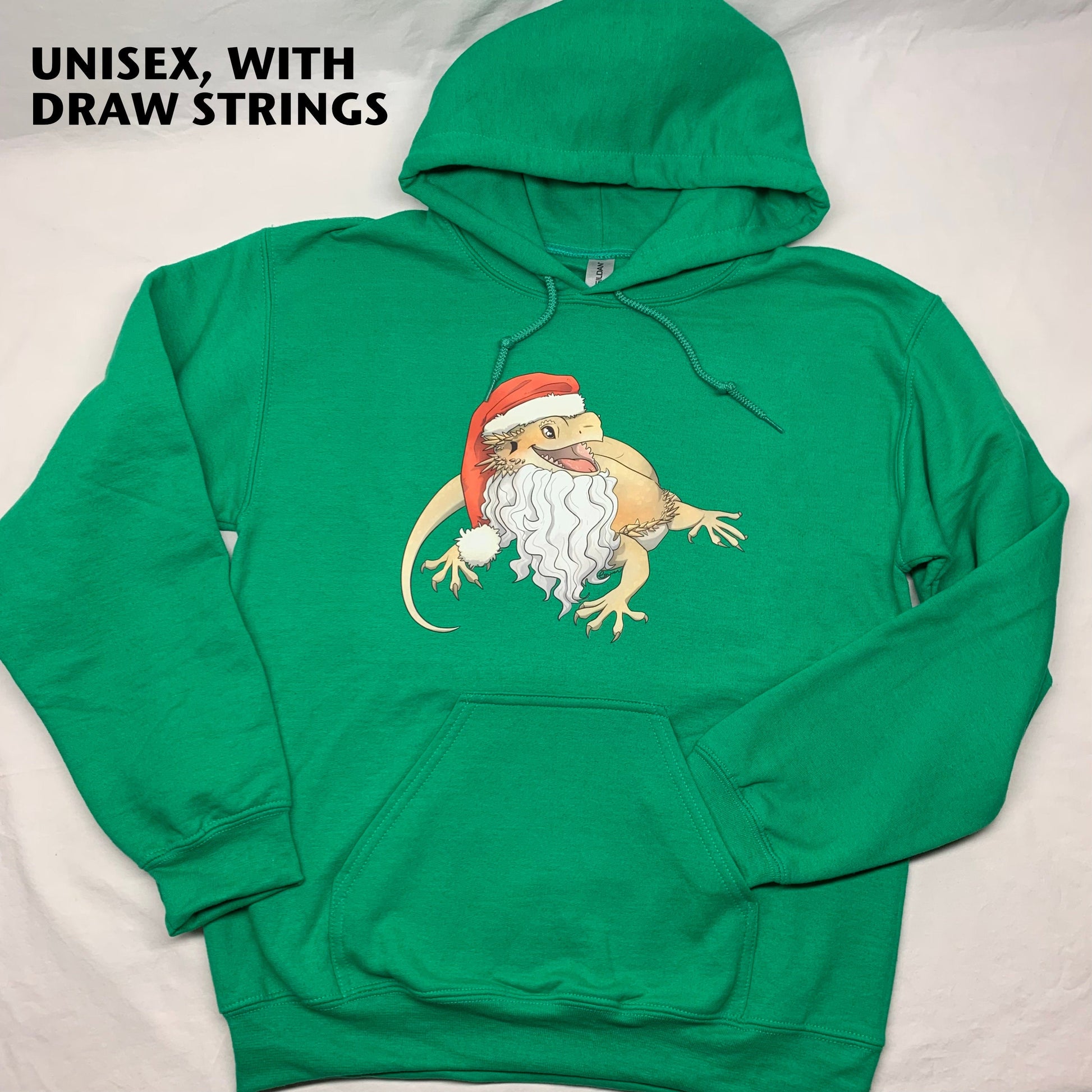 A photo of Amphisbaena Exotics original art of a cartoon realistic bearded dragon, smiling and wearing a Santa hat and beard on a Kelly green pullover hoodie, showing that the unisex sizes have drawstrings in the hoodie. Christmas themed.